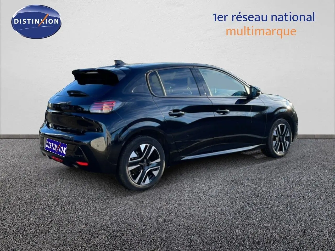Vue 3/4 arrière droite d'une Peugeot 208 noire 2025 avec jantes alliage et toit noir brillant.