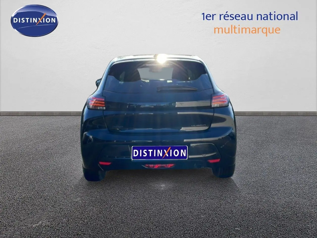 Vue arrière d'une Peugeot 208 noire 1.2 Hybrid 110ch e-DCS6 Allure, stationnée sur sol gris devant un mur blanc.