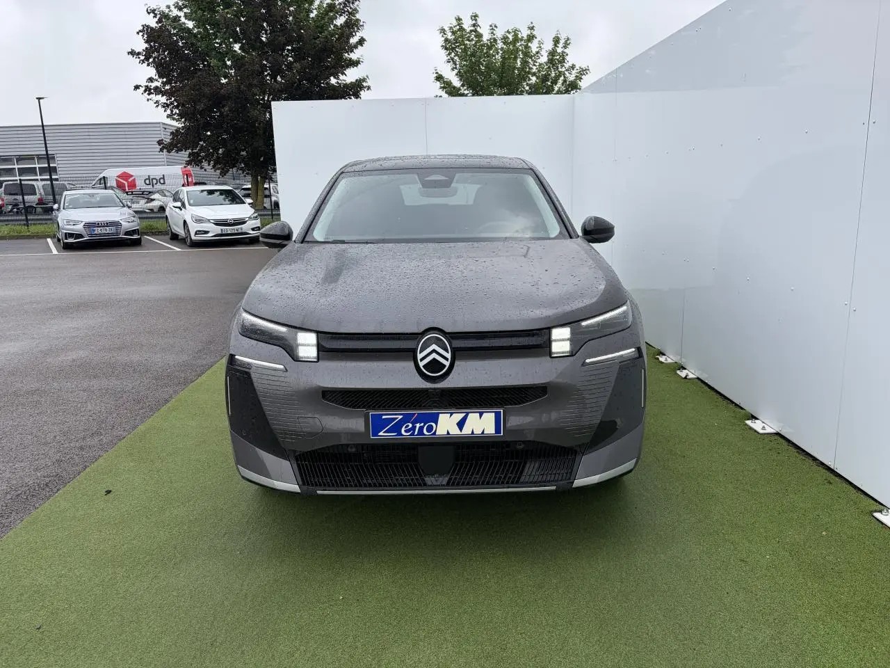 Vue frontale d'un Citroën C5 Aircross 2026 gris platinium avec toit noir et feux LED distinctifs allumés.