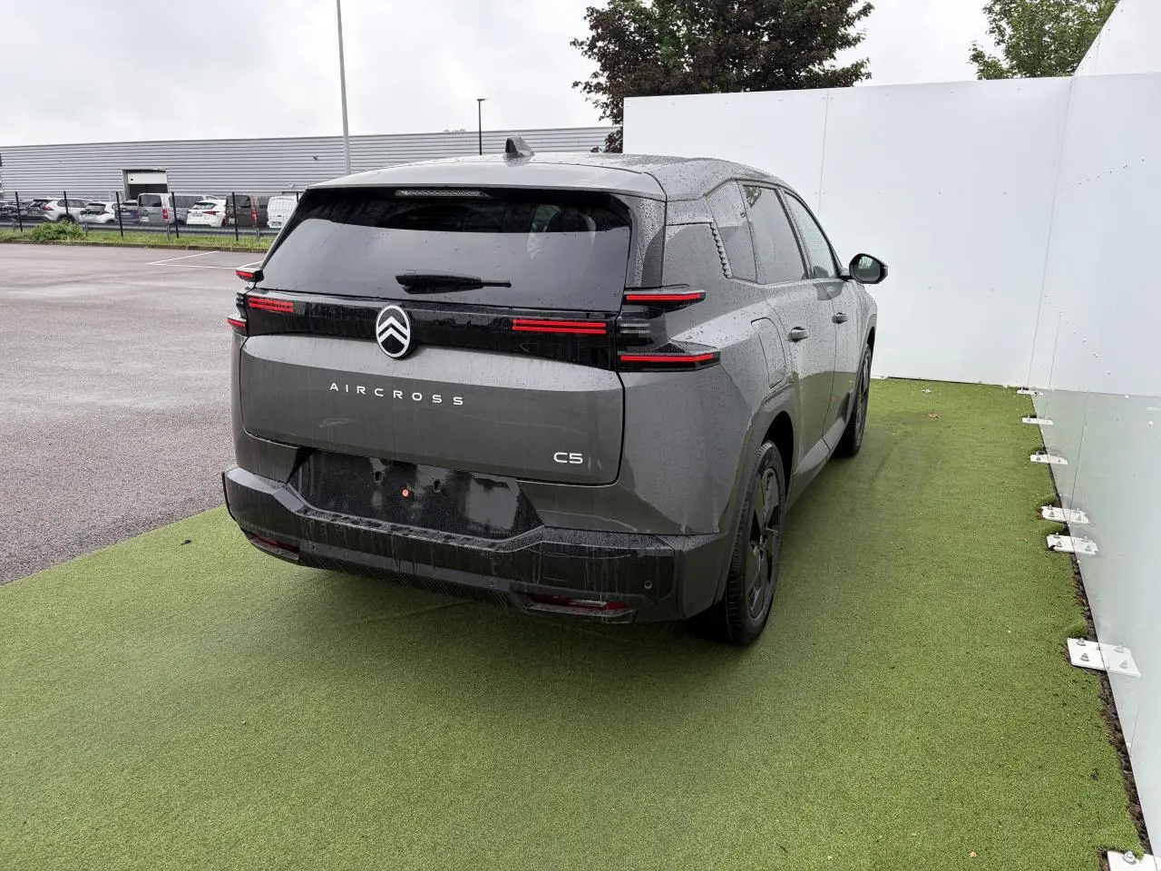 Vue 3/4 arrière droite d'une Citroën C5 Aircross 2026 gris platinium avec toit noir et feux arrière LED distinctifs.