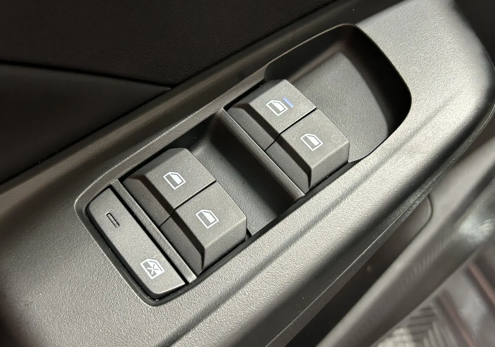 Gros plan sur les commandes des vitres électriques côté conducteur du MG3 1.5 Hybrid+ 195 LUXURY en intérieur noir.