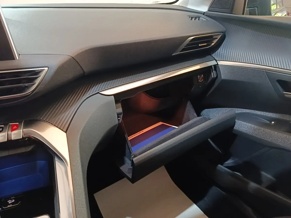 Vue intérieure côté passager du Peugeot 5008 2018, boîte à gants ouverte avec éclairage intérieur visible.
