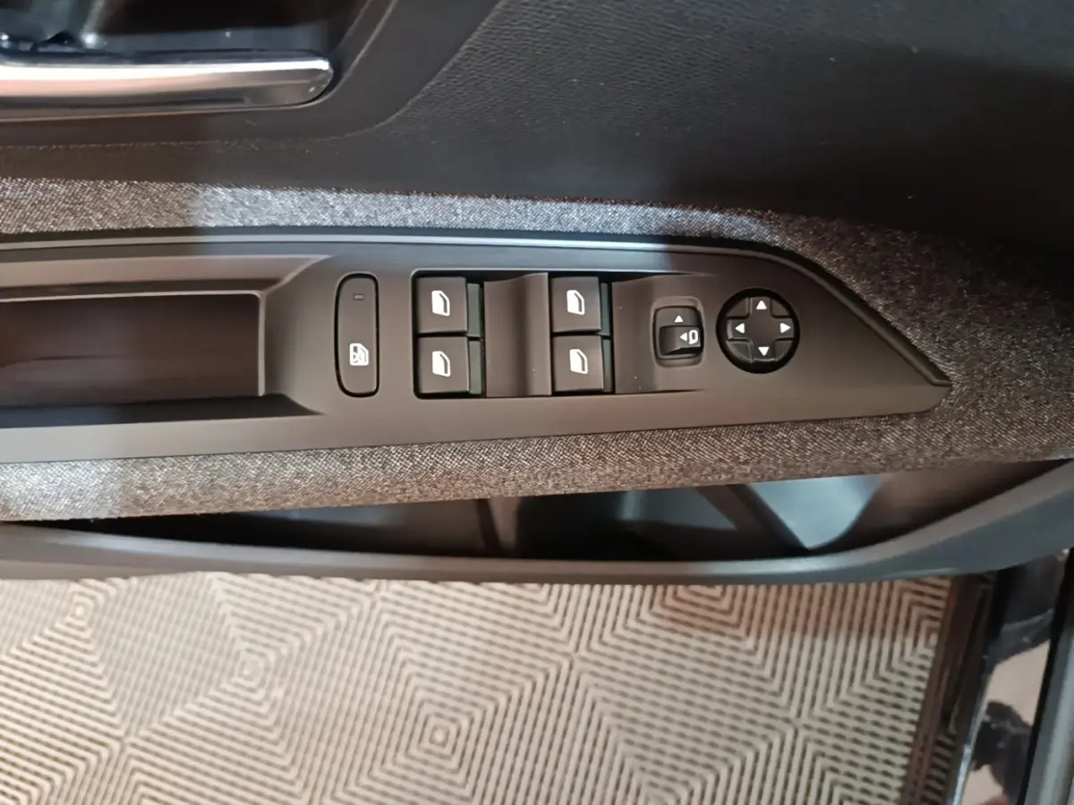 Commande des vitres et réglage des rétroviseurs sur la porte côté conducteur d’un Peugeot 5008 noir 2018.