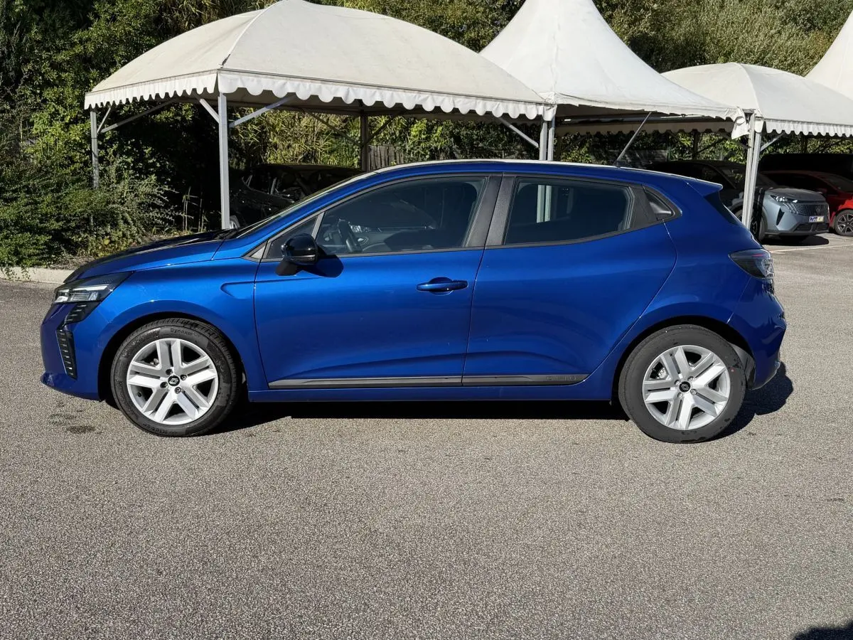 Profil droit de la Renault Clio Evolution TCe 90 2024 en bleu, avec jantes argentées et rétroviseurs noirs.