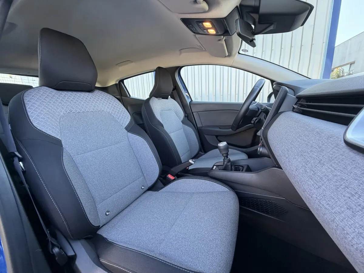 Vue intérieure côté droit de la Renault Clio Evolution TCe 90 2024, sièges tissu gris et tableau de bord assorti.