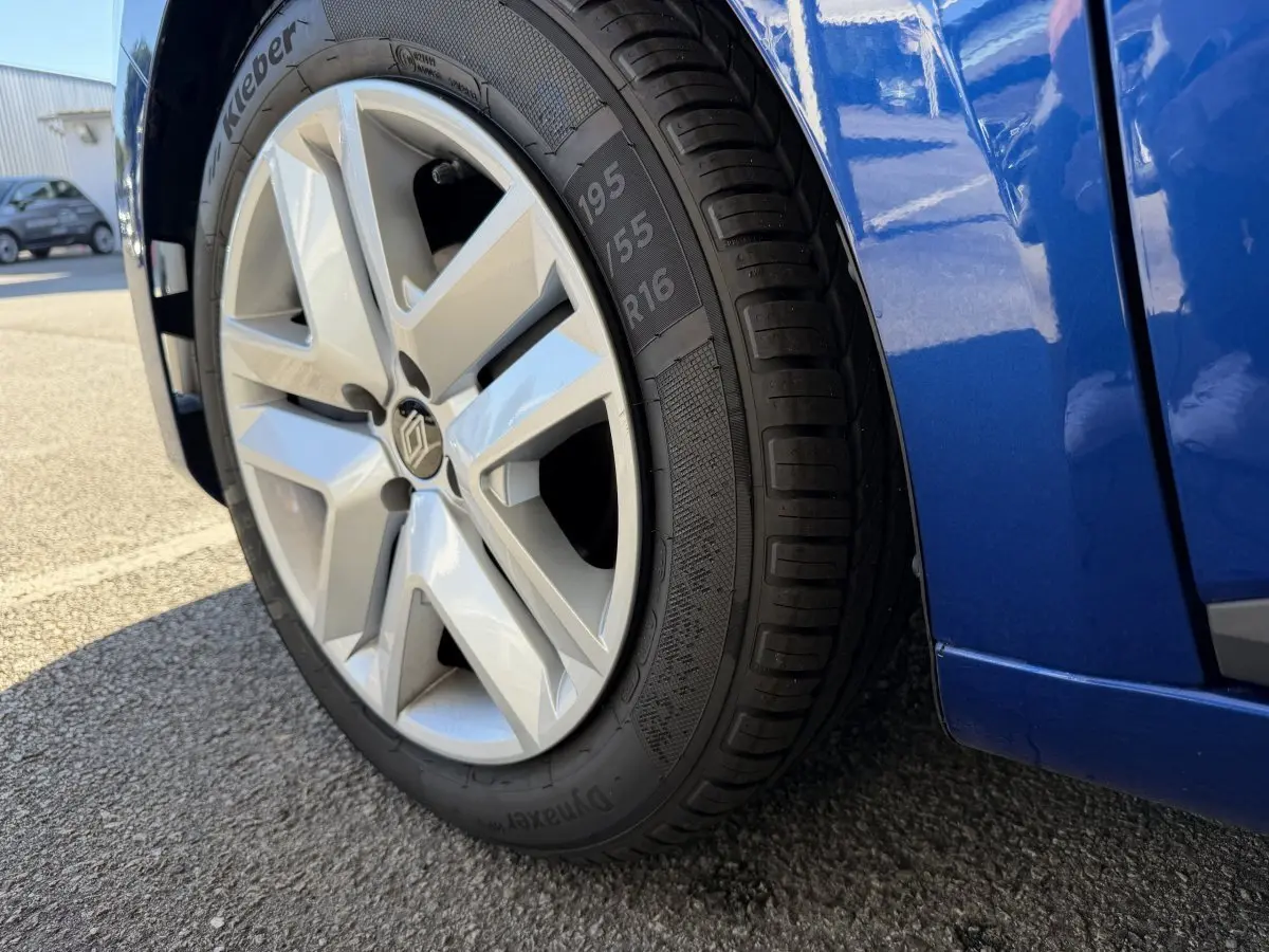 Gros plan sur la roue avant gauche et la partie basse bleue d'une Renault Clio Evolution TCe 90 2024.