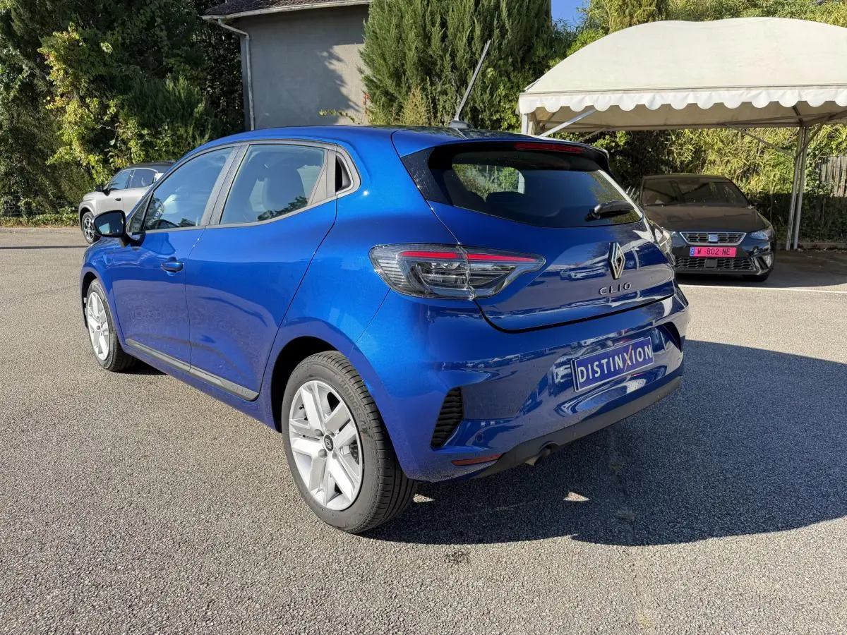 Vue 3/4 arrière droite d'une Renault Clio Evolution TCe 90 bleu brillant avec feux arrière LED et jantes alliage.