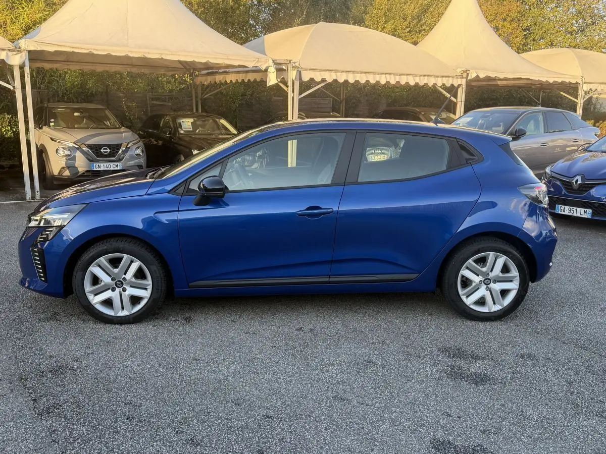 Profil droit d'une Renault Clio Evolution TCe 90 bleu 2024, avec jantes alliage et rétroviseurs noirs, stationnée en extérieur.