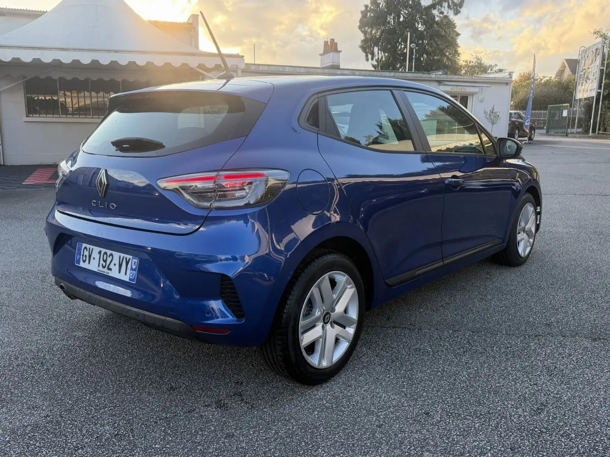 Vue 3/4 arrière droite d'une Renault Clio bleu 2024 avec feux LED et jantes alliage argentées.