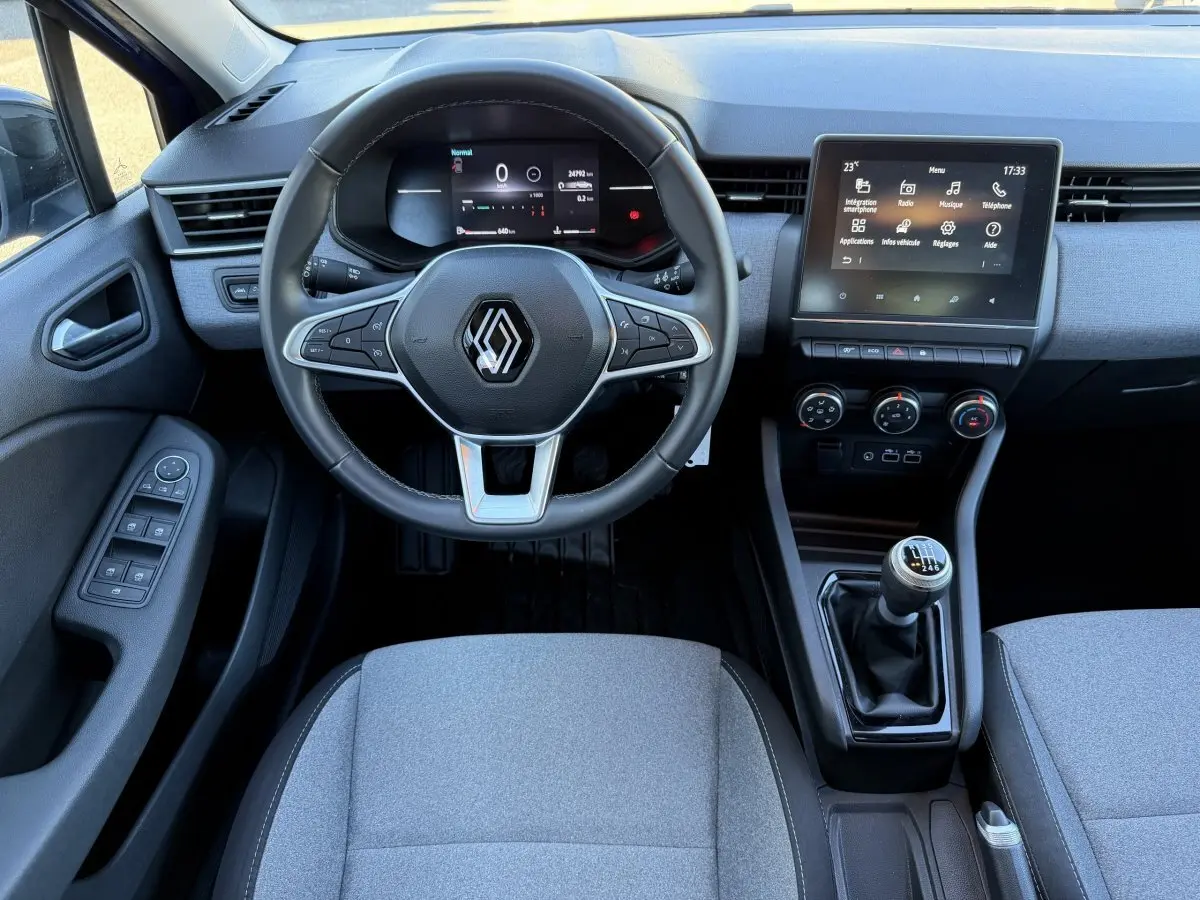 Vue intérieure avant de la Renault Clio Evolution TCe 90 2024, volant cuir multifonctions et écran tactile central.