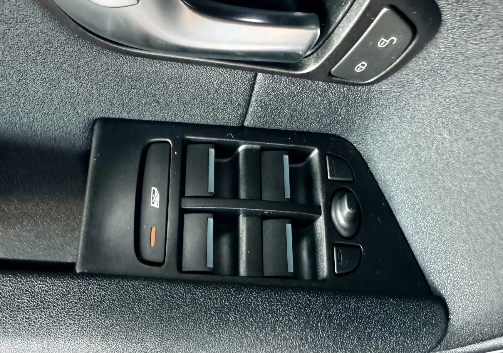 Panneau de commande des vitres et verrouillage sur la portière côté conducteur d'un Range Rover Evoque noir.