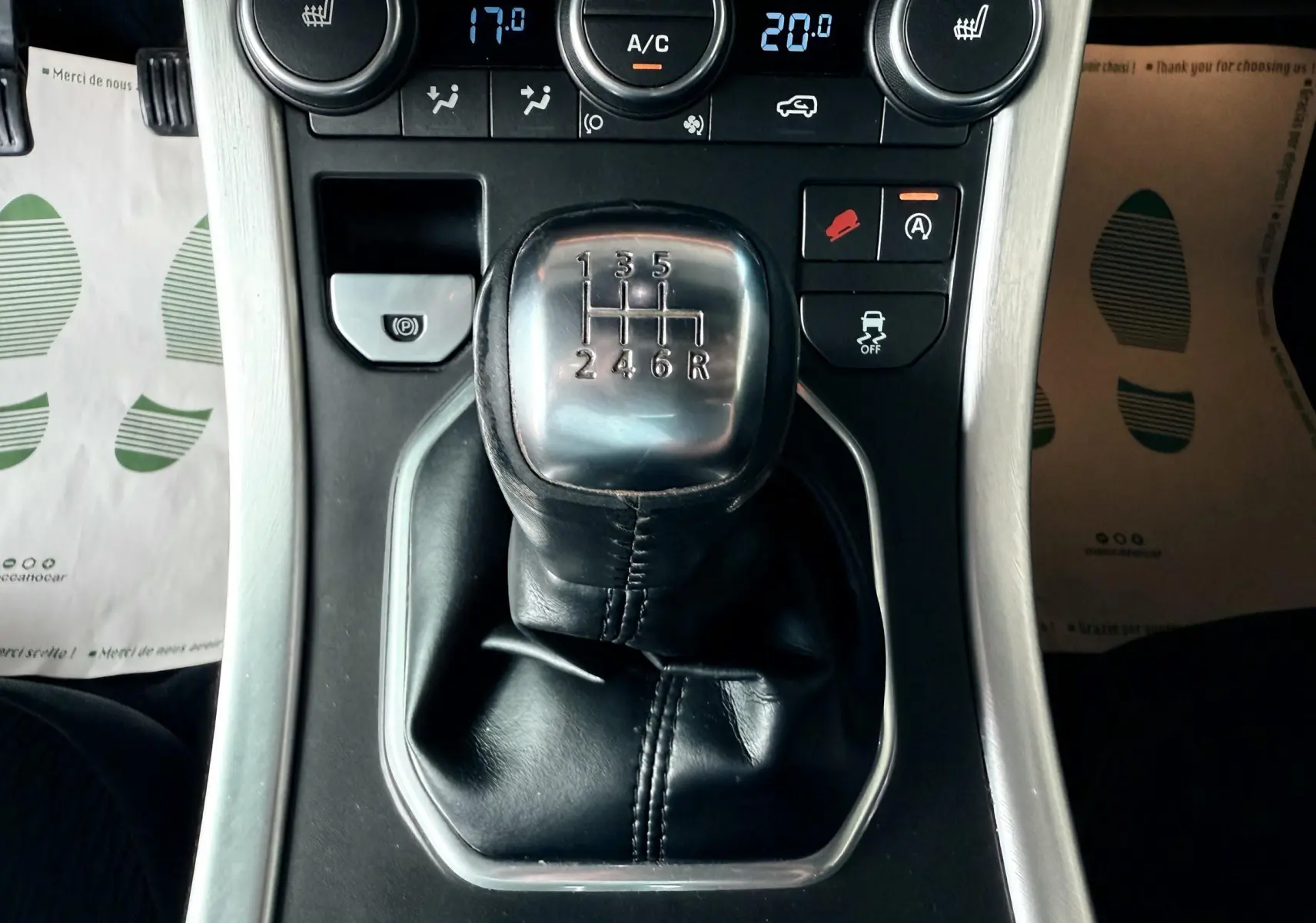 Gros plan sur le levier de vitesses manuel noir du Range Rover Evoque 2017 avec commandes de climatisation visibles.