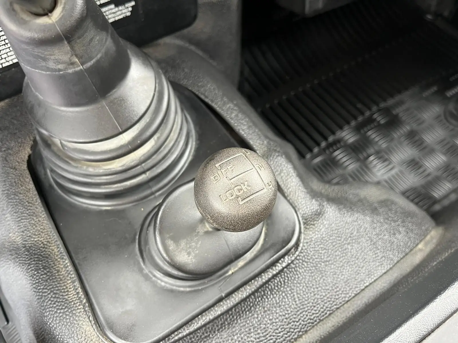 Gros plan sur le levier de blocage de différentiel du Land Rover Defender 90 Hard Top 2004, intérieur noir.
