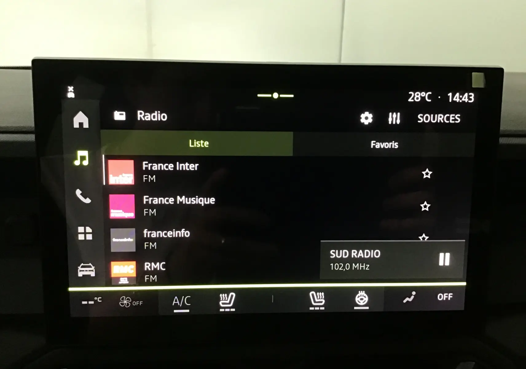 Écran tactile central du Dacia Duster 2025 affichant la liste des radios FM avec interface en mode sombre.