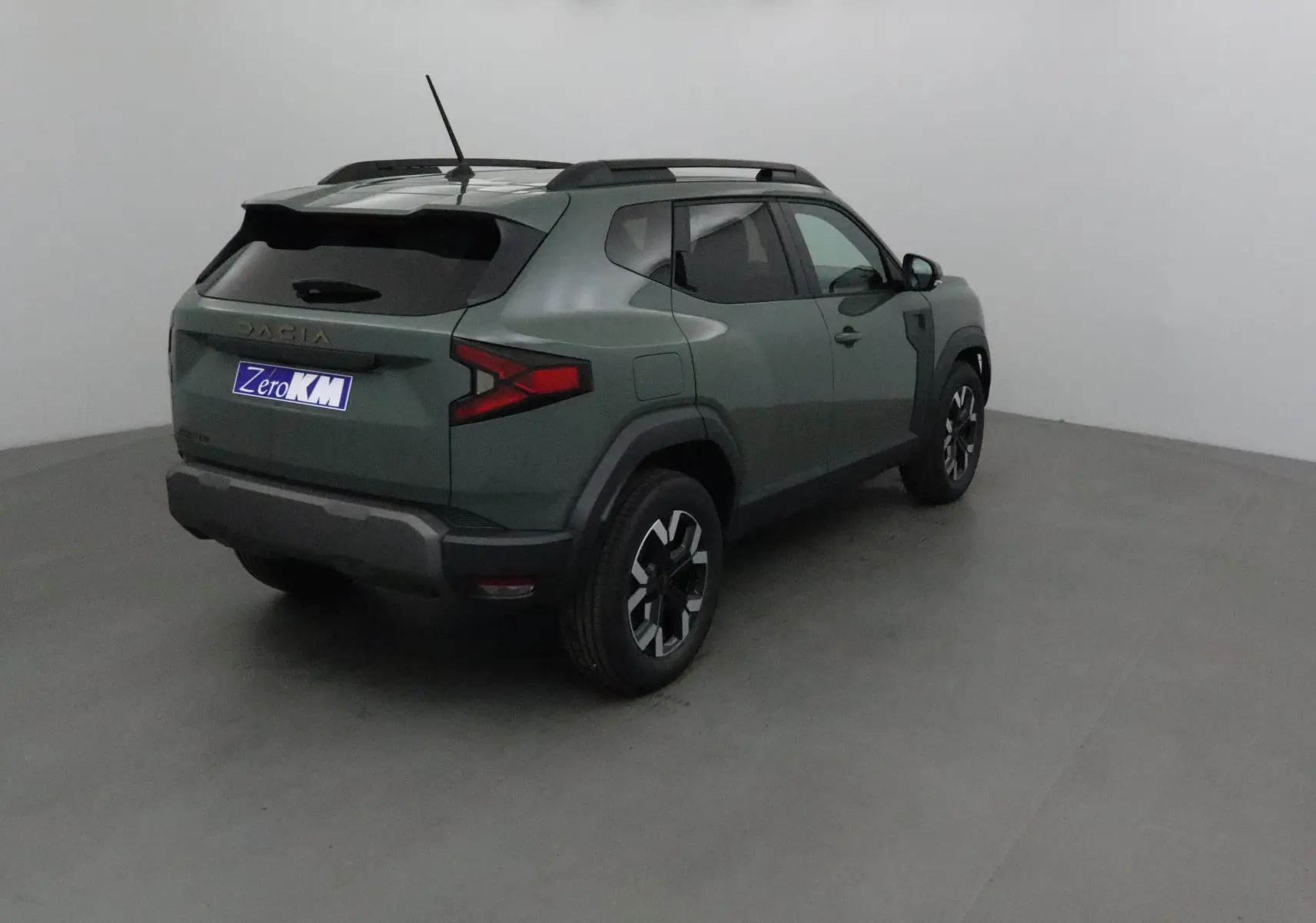 Vue 3/4 arrière droite du Dacia Duster 2025 kaki lichen avec jantes noires et toit noir contrasté.