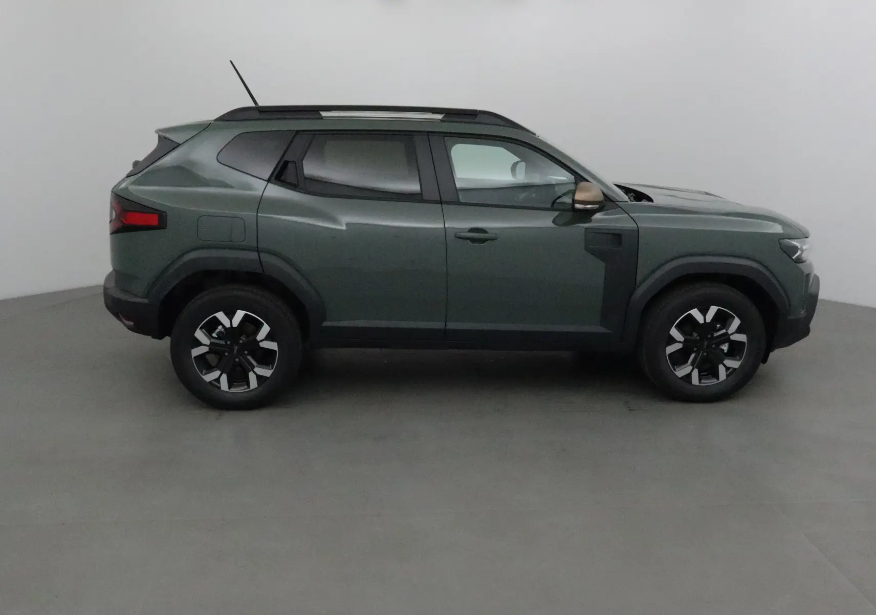 Profil droit du Dacia Duster 2025 en kaki lichen, avec jantes noires et détails noirs contrastants sur les ailes.