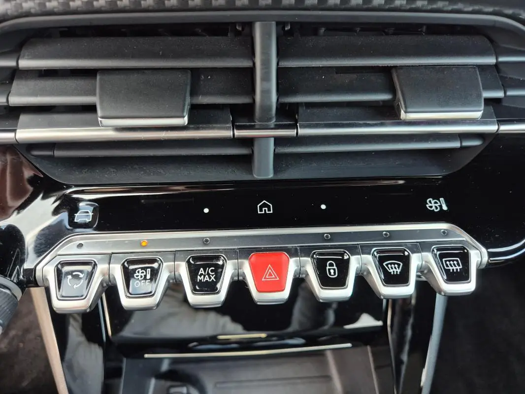 Vue rapprochée des commandes centrales du tableau de bord noir du Peugeot 2008 Hybrid 145 e-DCS6 GT 2024.