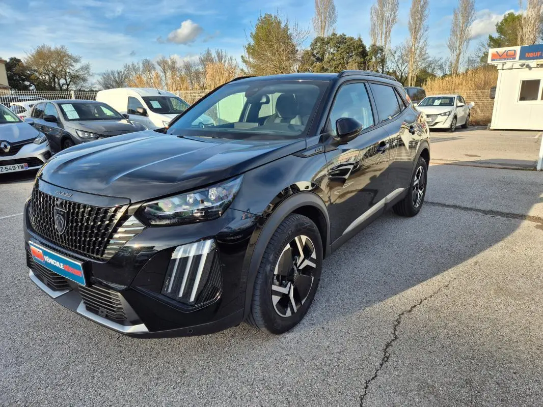 Peugeot 2008 Hybrid 145 e-DCS6 GT noir en 3/4 avant droit avec barres de toit et jantes alliage 18 pouces.
