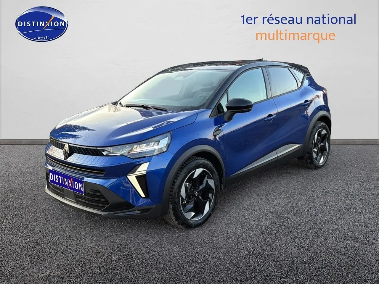 Renault Captur 2026 bleu iron et noir en 3/4 avant, avec jantes alu noires et toit noir contrasté.