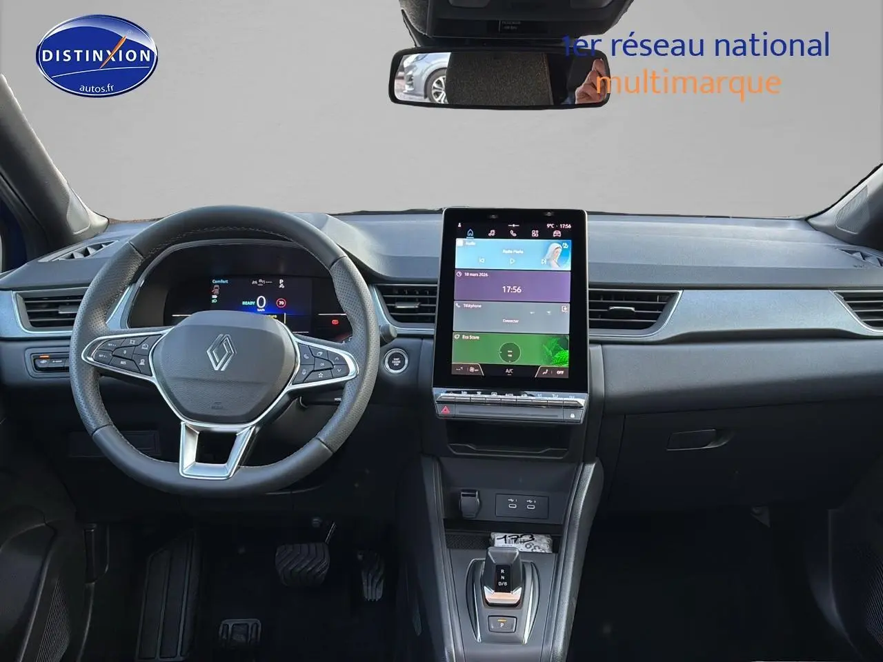 Vue intérieure frontale du tableau de bord du Renault Captur bleu iron, avec écran tactile vertical et volant multifonction.