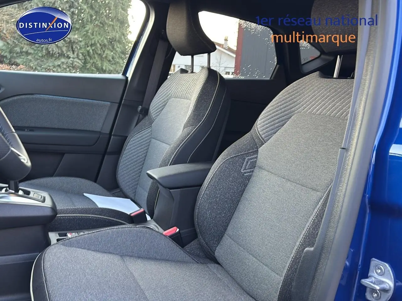 Vue intérieure côté droit montrant les sièges avant gris et l'accoudoir central du Renault Captur bleu iron 2026.