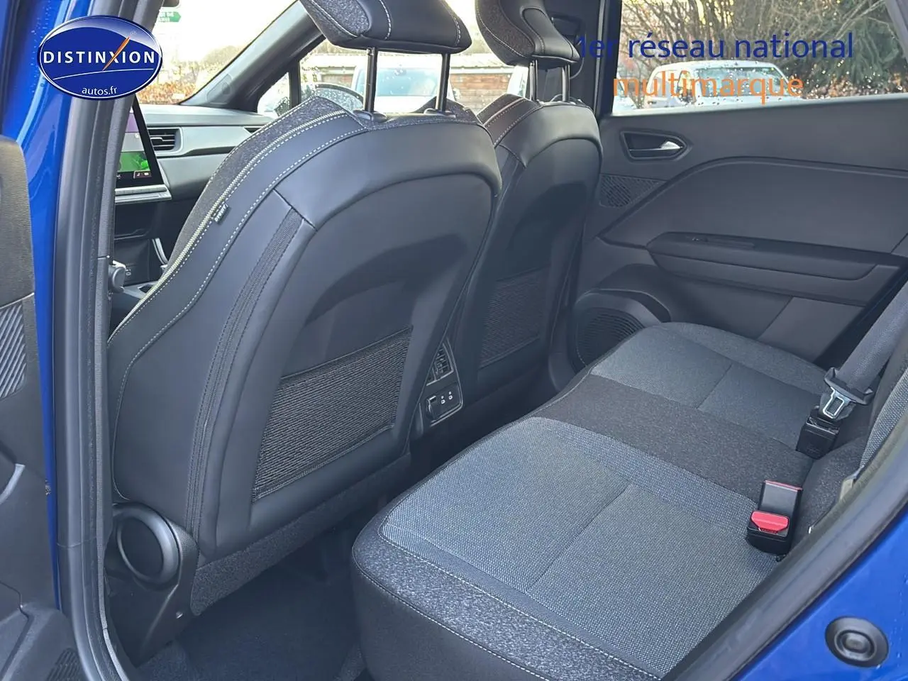 Vue intérieure arrière côté droit du Renault Captur bleu iron, montrant les sièges arrière et le dossier des sièges avant en cuir noir.