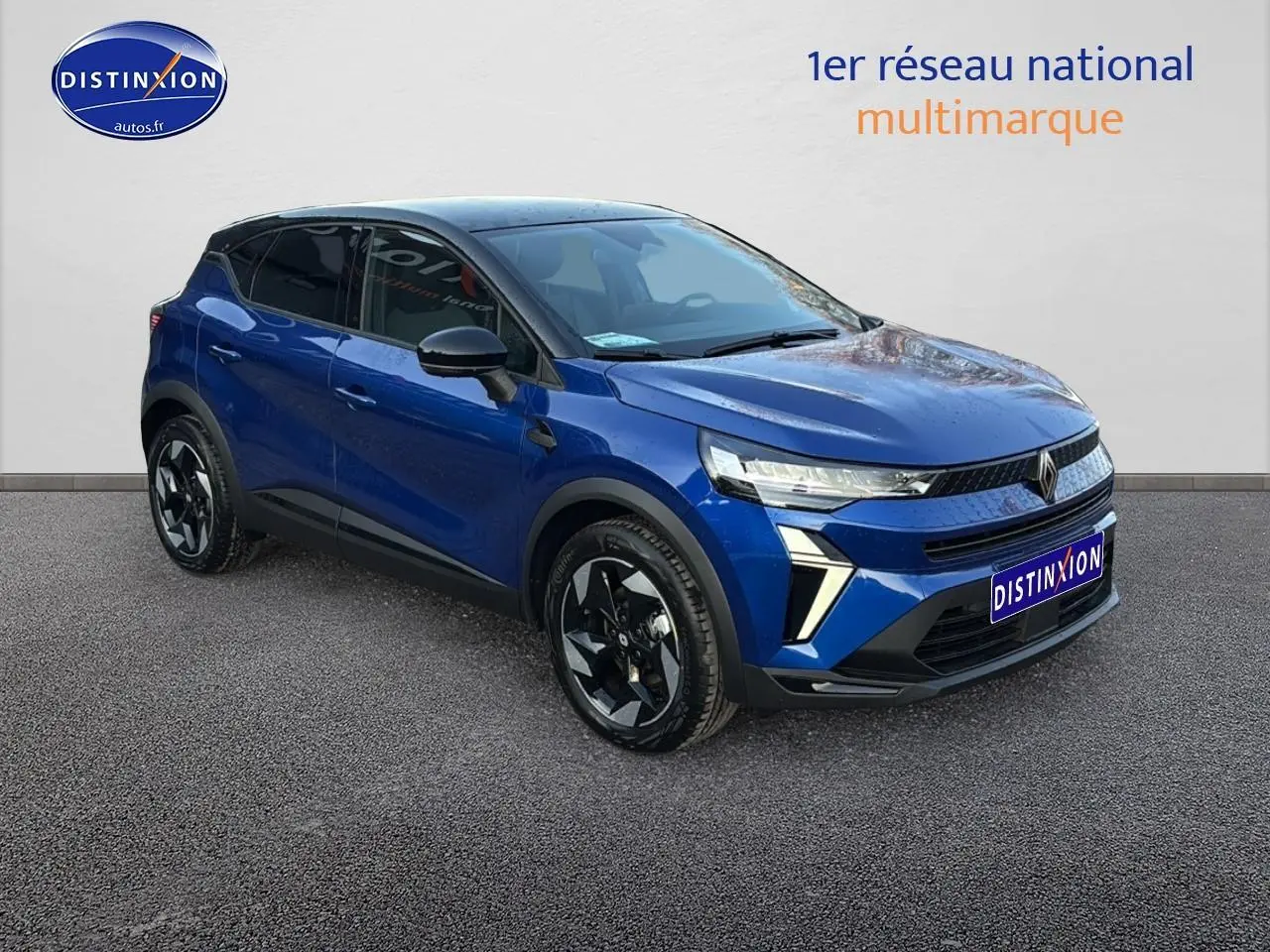 Renault Captur 2026 bleu iron et noir en 3/4 avant droit, avec jantes alu et feux LED distinctifs.