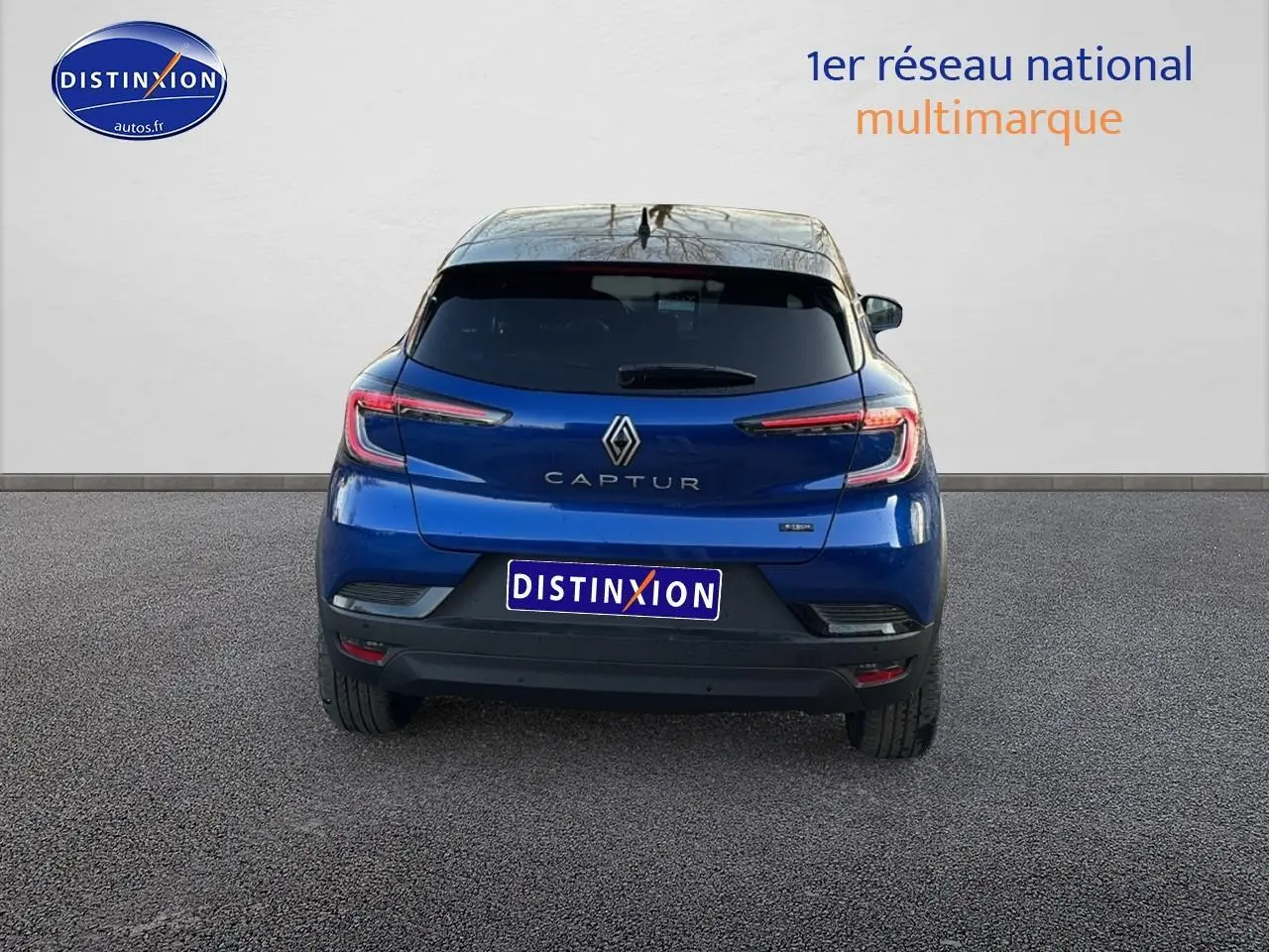 Vue arrière d'un Renault Captur bleu iron avec toit noir, feux arrière LED et logo central bien visibles.