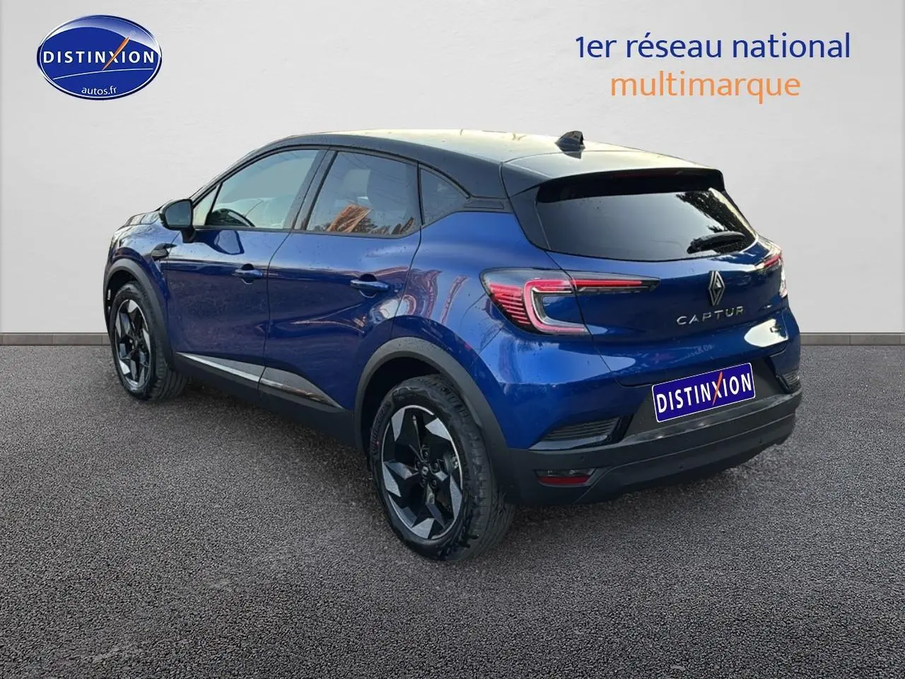 Vue 3/4 arrière droite du Renault Captur bleu iron avec toit noir et jantes alu noires.