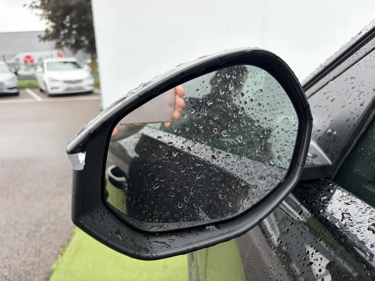 Rétroviseur extérieur droit noir métallisé de Citroën C5 Aircross II sous pluie avec gouttes d'eau visibles.