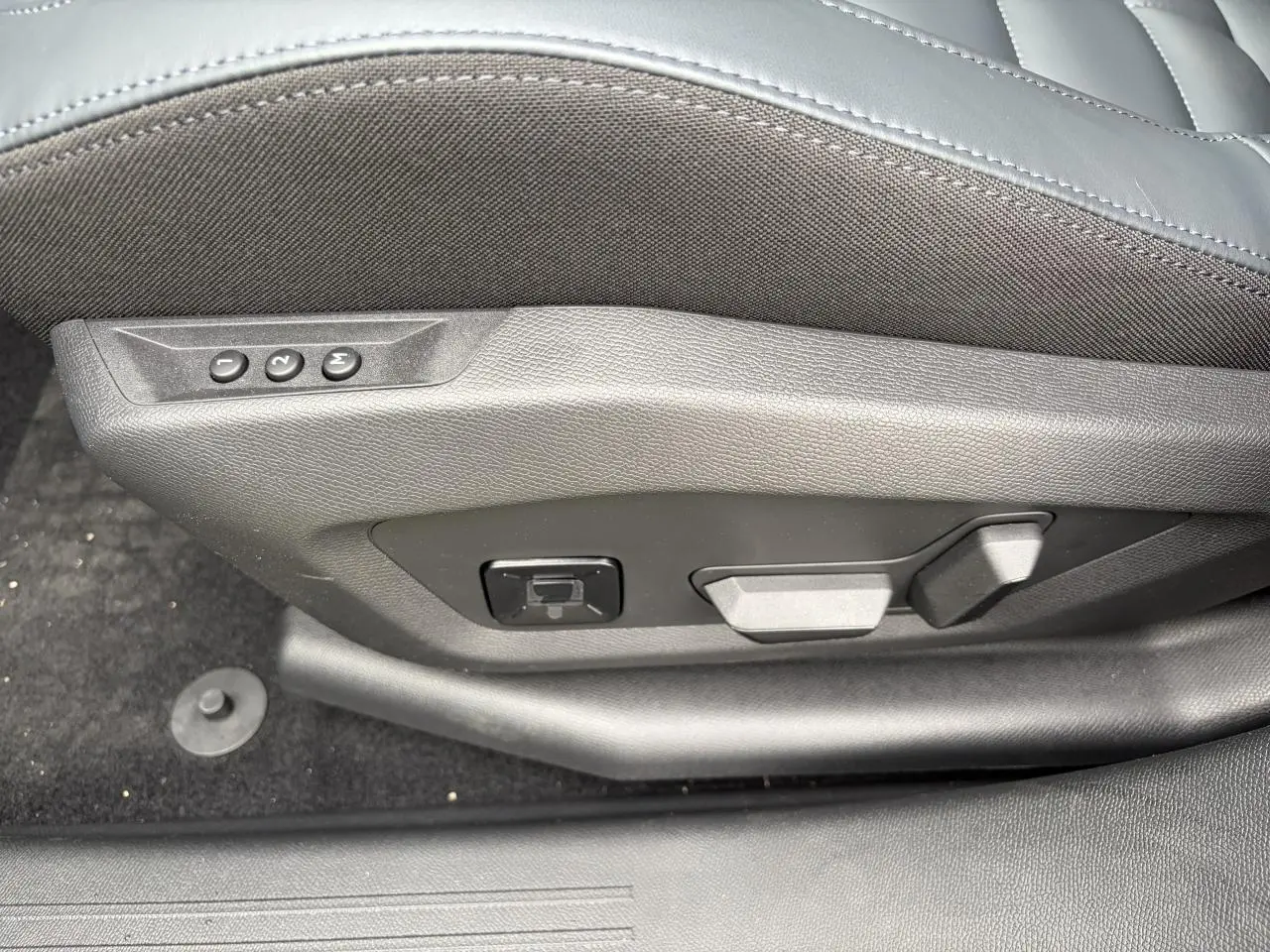Gros plan sur les commandes de réglage électrique du siège conducteur noir du Citroën C5 Aircross hybride 2026.