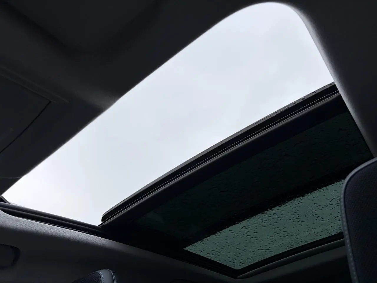 Toit ouvrant panoramique ouvert vu de l'intérieur d'un Citroën C5 Aircross noir métal.