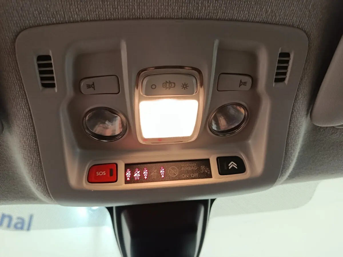 Vue en gros plan du plafonnier intérieur avec éclairage et boutons de commande de la Citroën C3 blanche 2020.