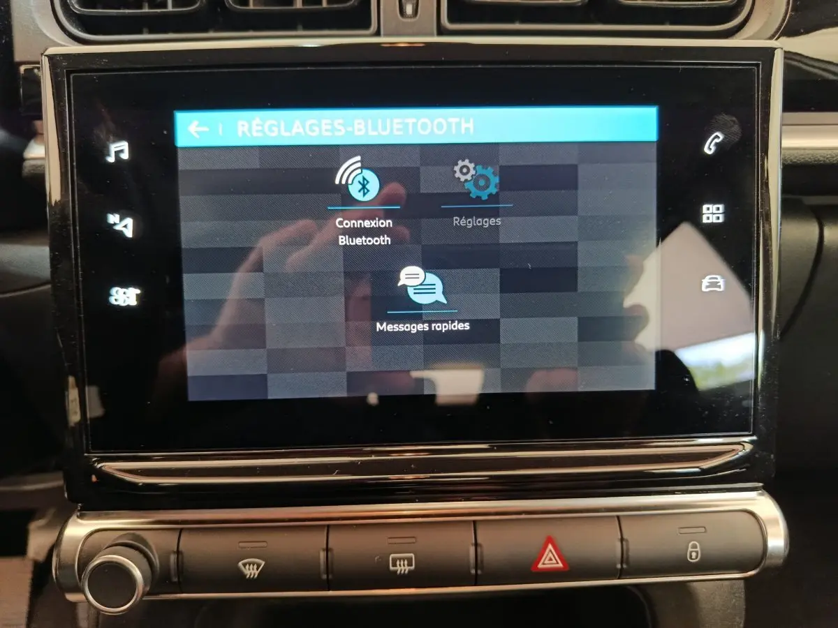 Écran tactile central de la Citroën C3 blanche, affichant les réglages Bluetooth en gros plan intérieur.