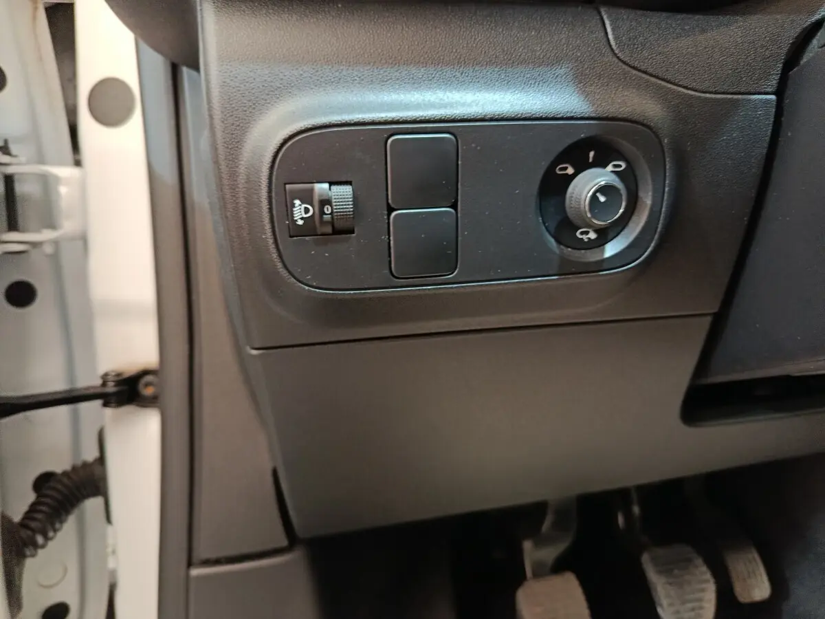 Vue intérieure côté gauche du tableau de bord d'une Citroën C3 blanche, avec commandes des phares et rétroviseurs.