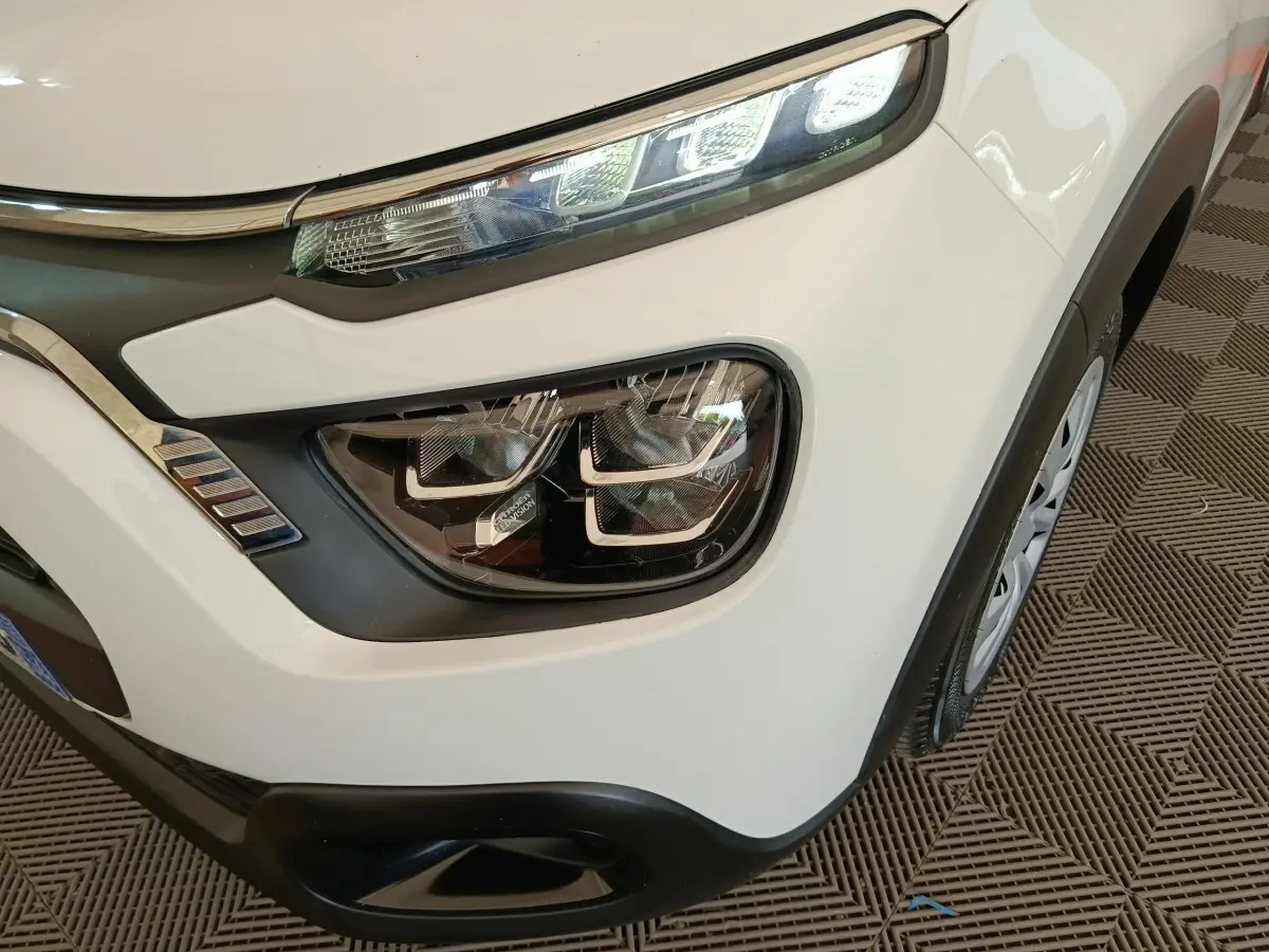 Gros plan sur le phare avant droit blanc de la Citroën C3 2020 avec détails LED et partie de la roue visible.