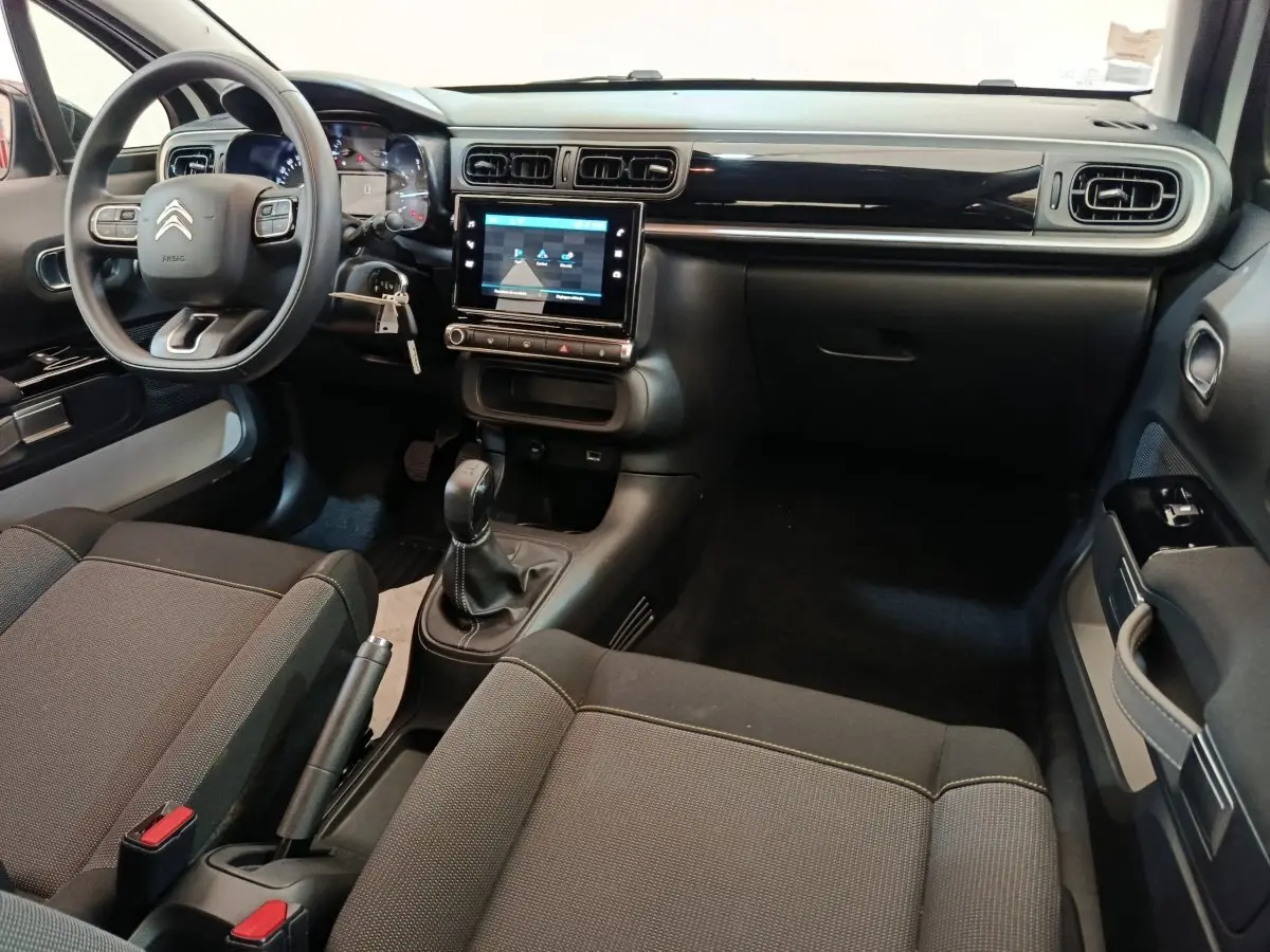 Vue intérieure avant droite du Citroën C3 blanc 2020, montrant le tableau de bord avec écran tactile et volant multifonctions.