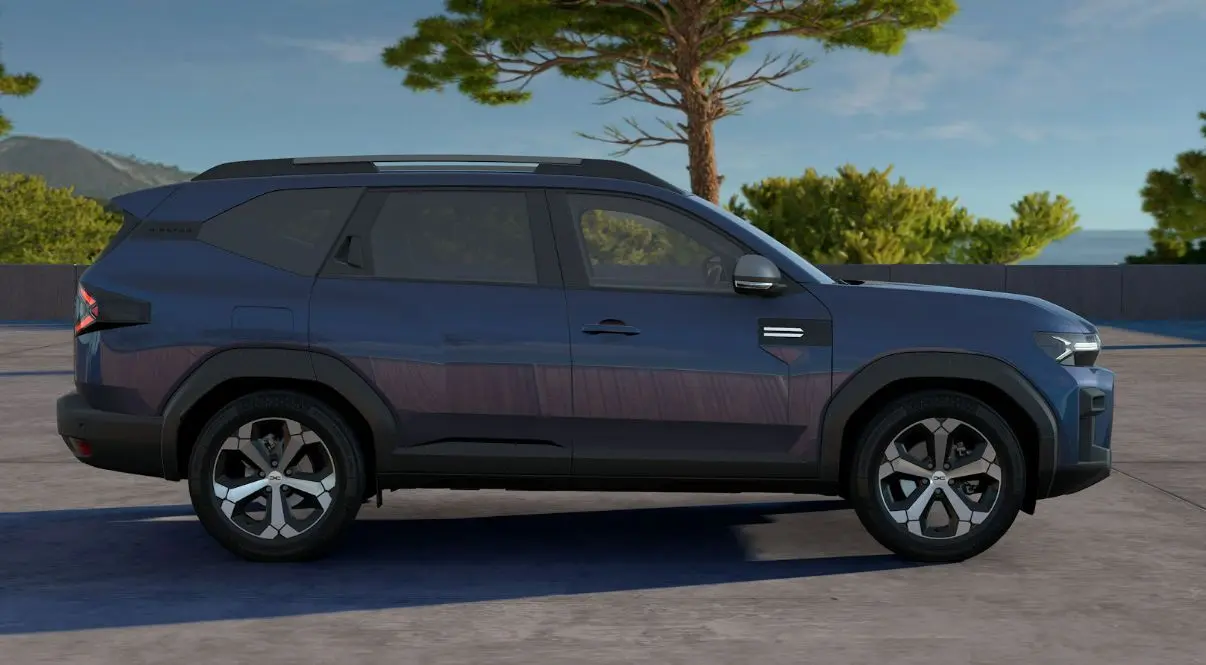 Profil droit du SUV Dacia Bigster bleu indigo 2026 avec jantes bi-ton et lignes anguleuses marquées.