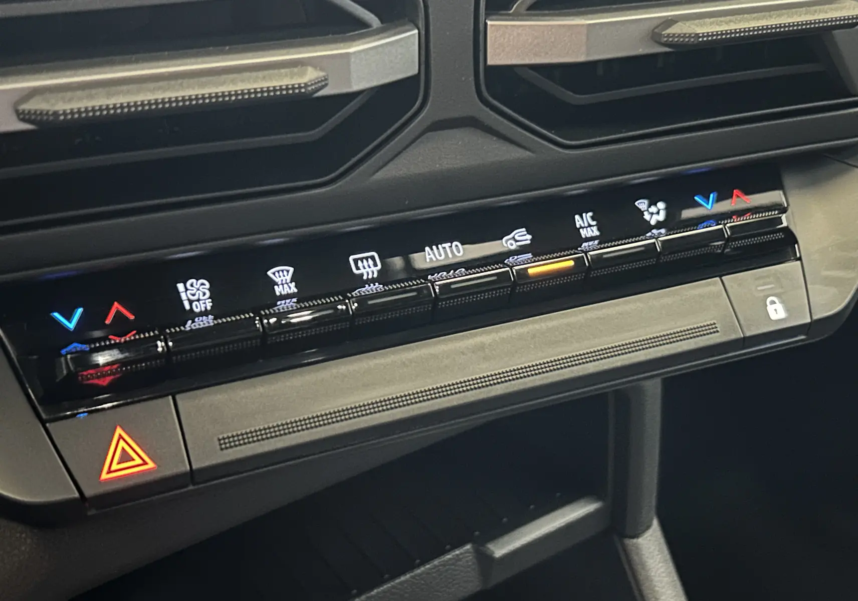 Gros plan sur la console centrale de la Dacia Bigster 2026, montrant les commandes tactiles de climatisation et le bouton de verrouillage.