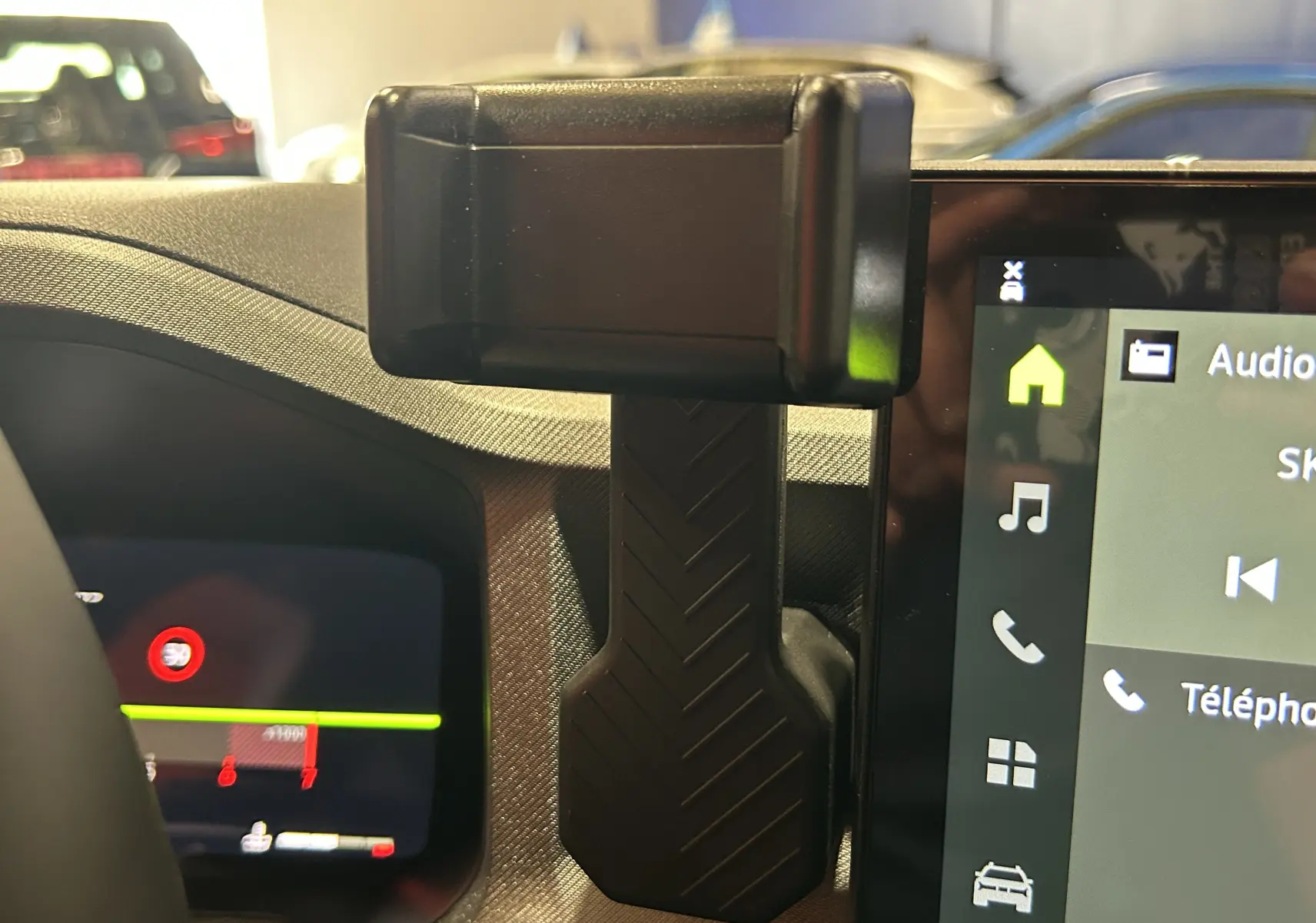 Vue rapprochée de la console centrale du Dacia Bigster 2026, mettant en valeur un support smartphone noir fixé entre l'écran tactile et le tableau de bord.