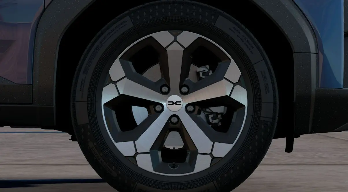 Gros plan sur la roue avant droite du Dacia Bigster bleu indigo, mettant en valeur la jante alliage au design moderne.