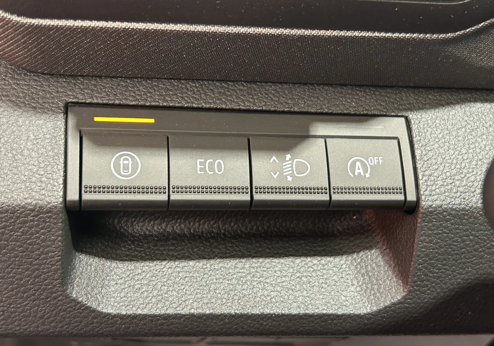 Boutons de commande intérieurs du Dacia Bigster 2026, vue rapprochée sur les fonctions ECO, réglage phares et arrêt auto start-stop.