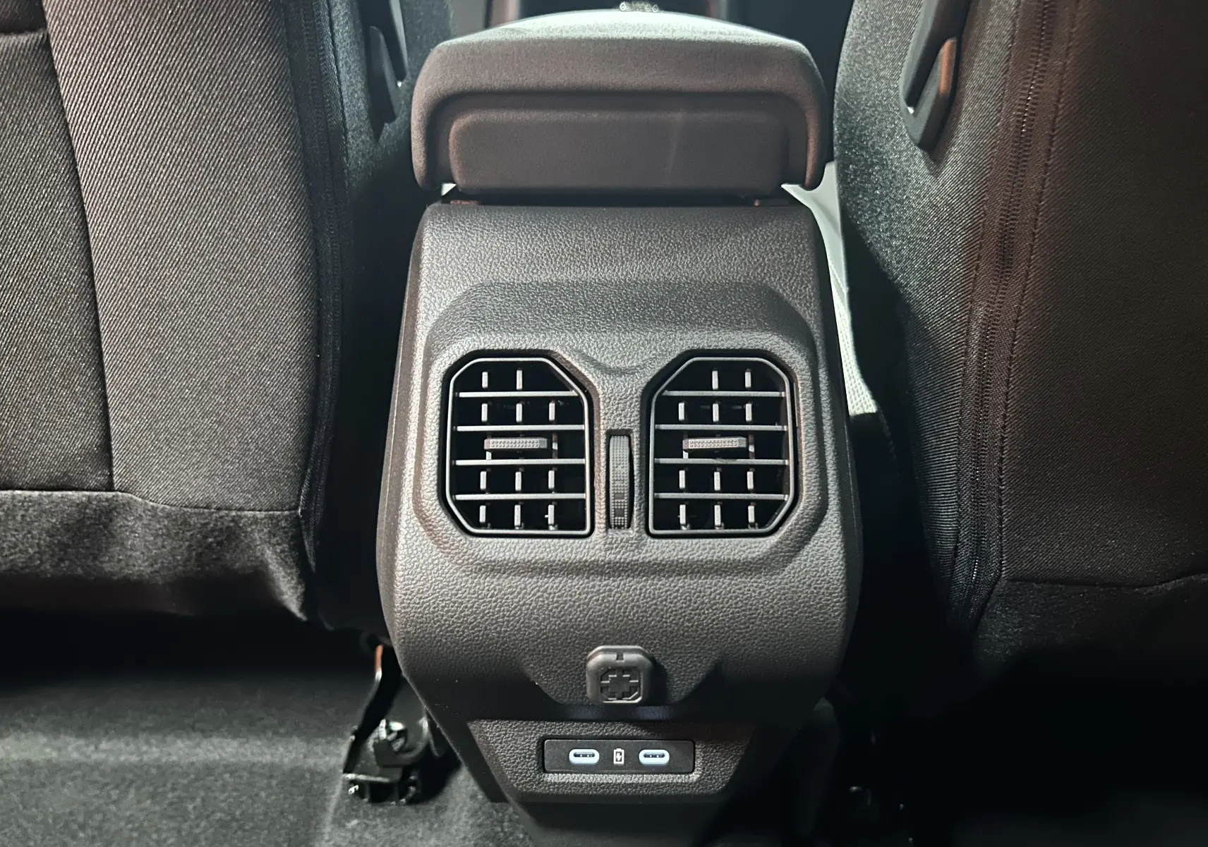 Vue rapprochée des aérateurs arrière et ports USB entre les sièges noirs du Dacia Bigster 2026.