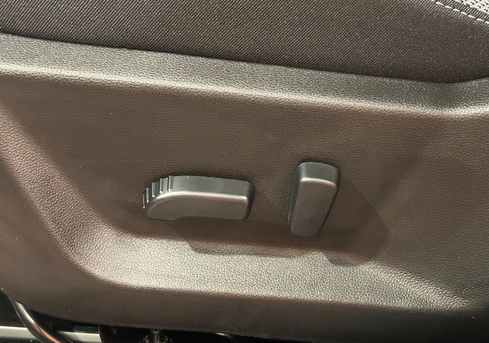 Gros plan sur les commandes de réglage électrique du siège avant en tissu du Dacia Bigster 2026.