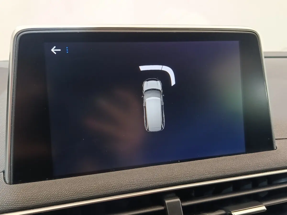 Écran tactile intérieur affichant la vue de dessus du véhicule en gris sur fond noir, tableau de bord Peugeot 5008.