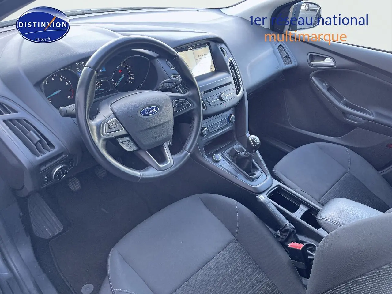 Intérieur de la Ford Focus SW 2018 vu côté conducteur, tableau de bord noir avec volant multifonction et boîte manuelle.