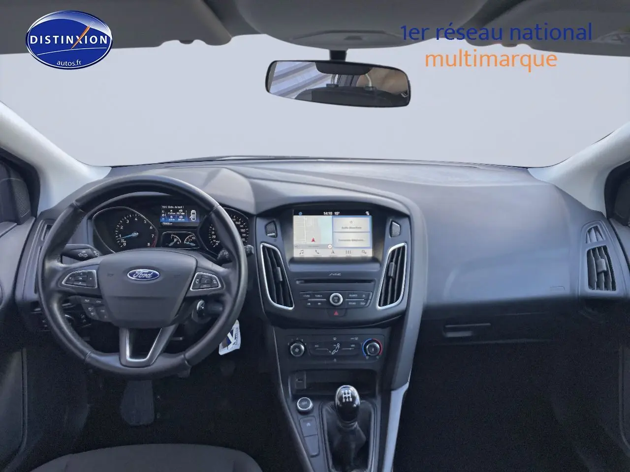 Vue intérieure frontale de la Ford Focus SW 2018, tableau de bord noir avec écran tactile et levier de vitesse manuel.