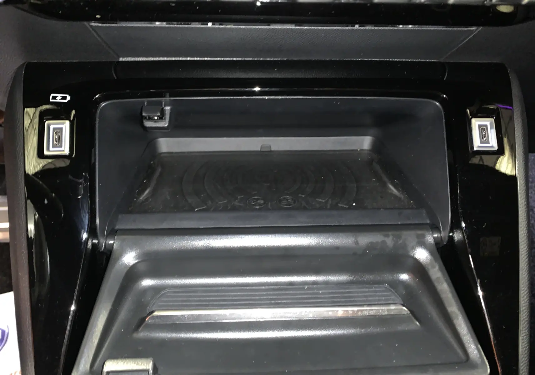 Rangement central ouvert avec plateau de recharge sans fil et ports USB dans le Peugeot 2008 gris 2023.