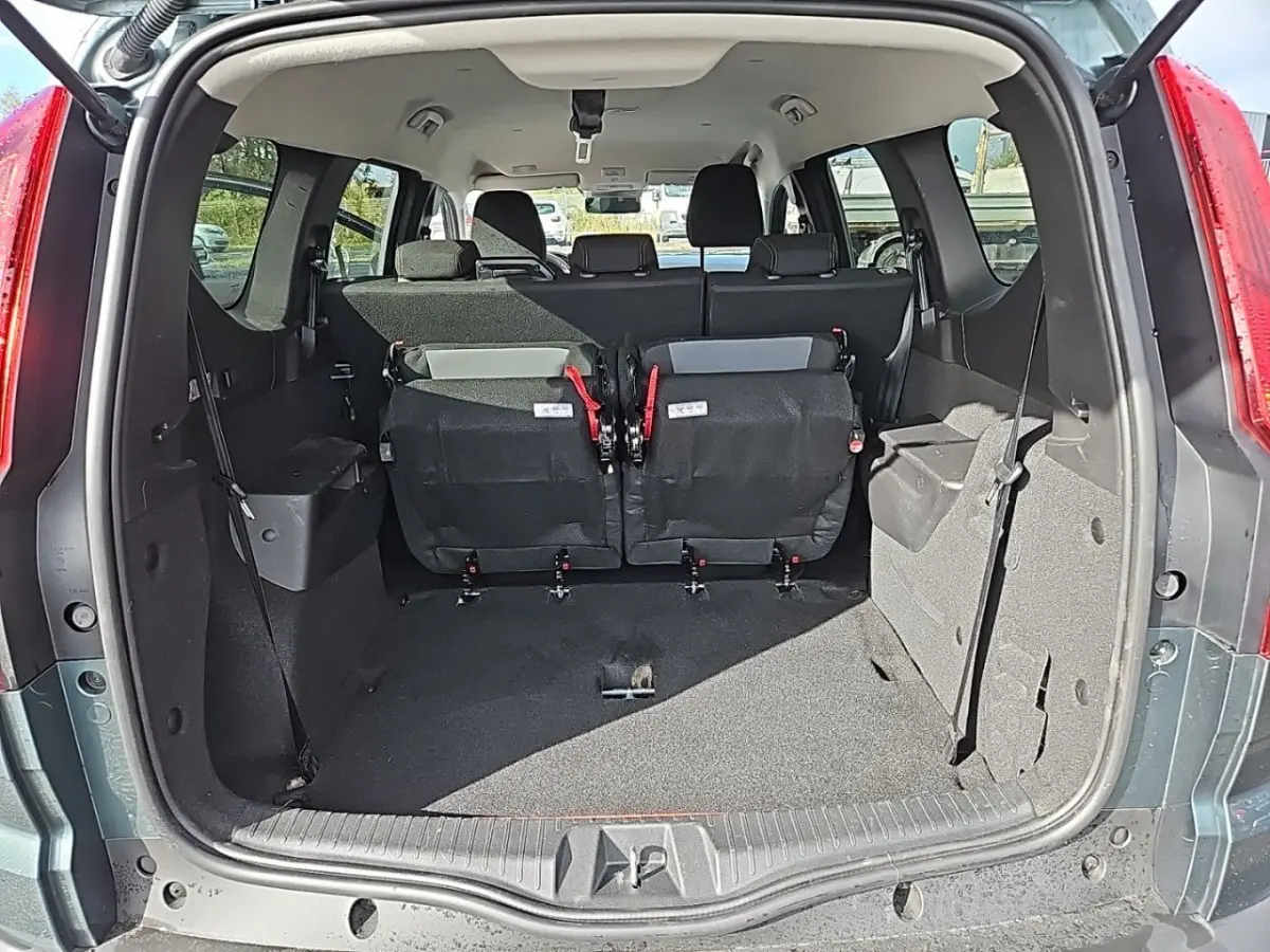 Vue arrière du coffre vert du Dacia Jogger Extreme Hybrid avec la troisième rangée de sièges rabattue en partie.