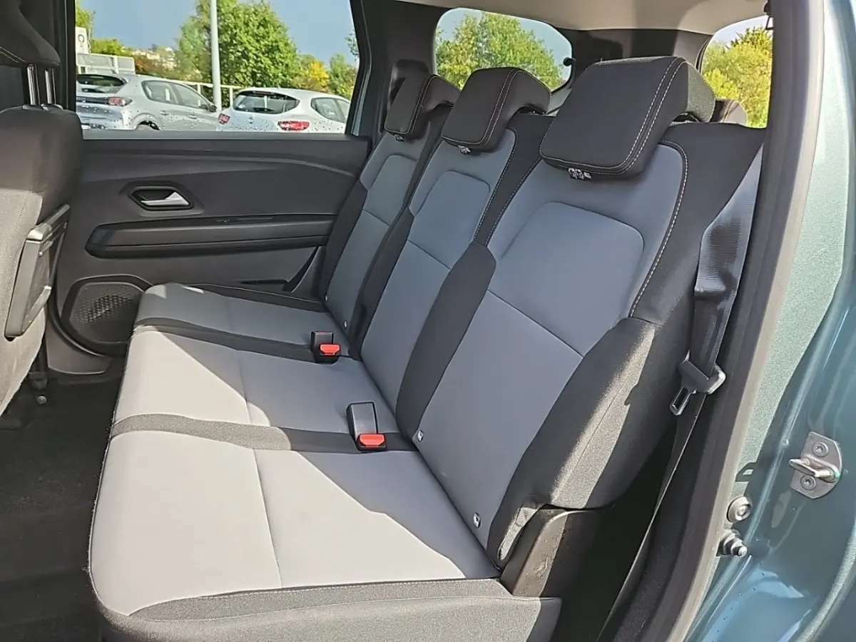 Banquette arrière 3 places en tissu gris et noir du Dacia Jogger vert, vue côté droit avec porte ouverte.
